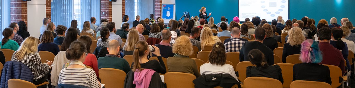 A group of people in a talk at the HRP conference