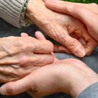 A young person holding an older persons hand