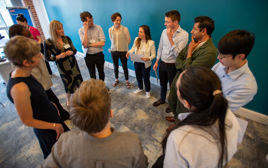 A group of people at an event in a circle having a conversation