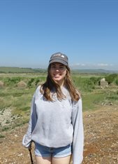 A headshot photo of Megan Harrison pictured outside in a field with blue skies